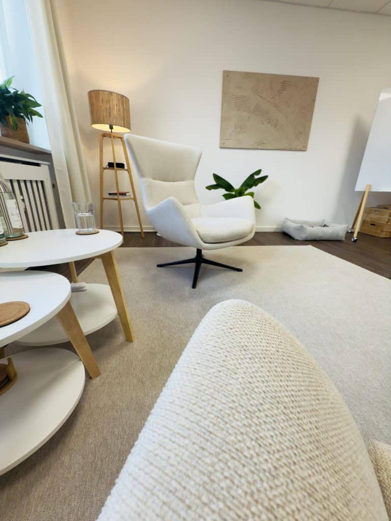 Hell eingerichteter Raum für Yogatherapie als Ergänzung zur Psychotherapie in Rosenheim mit gemütlichem Sessel und beruhigender Atmosphäre.